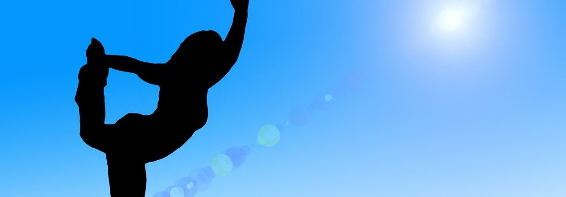 Yogahaltung vor einem blauen Himmel
